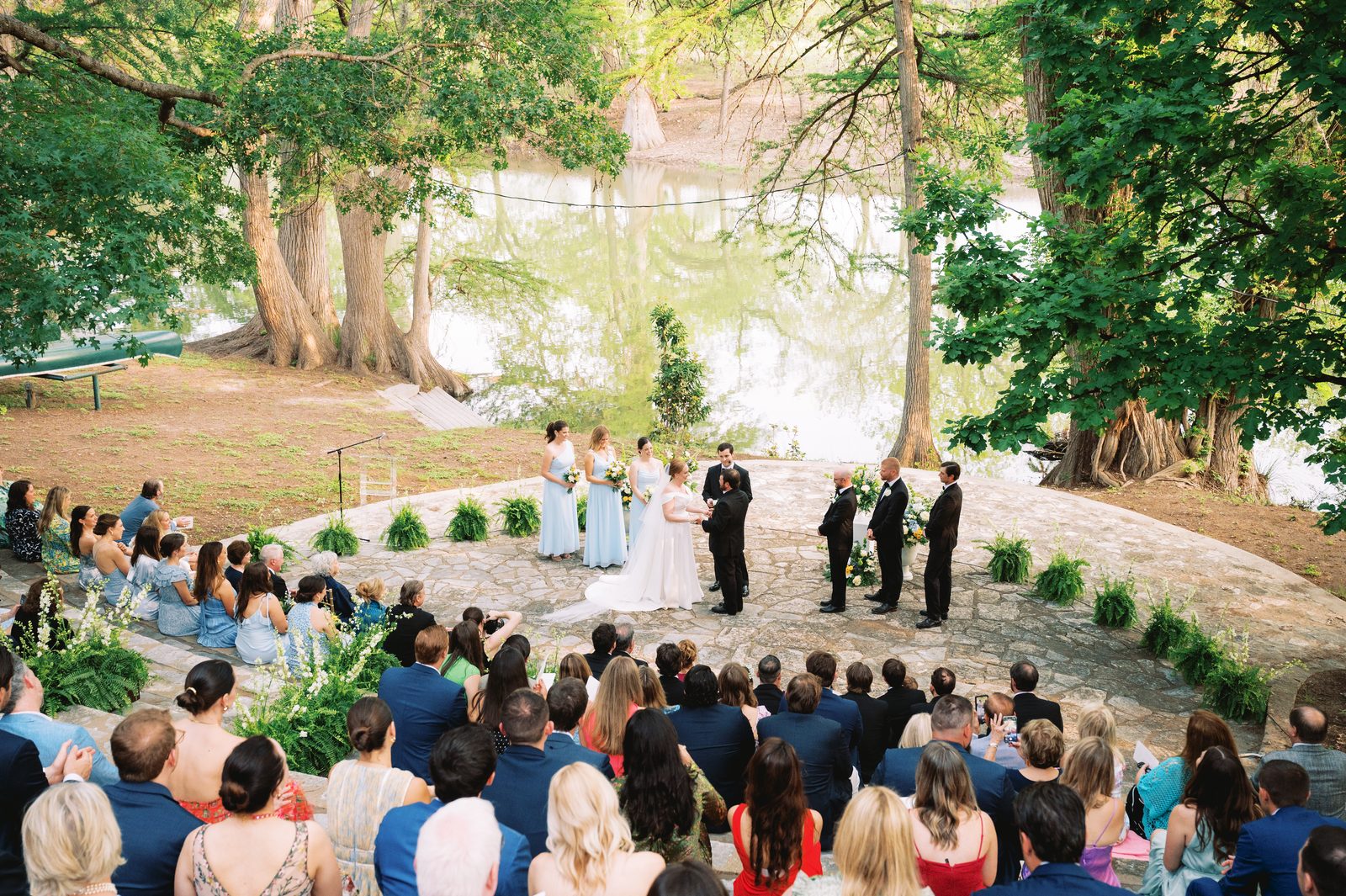 Outdoor ceremony beneath the oaks with seated guests