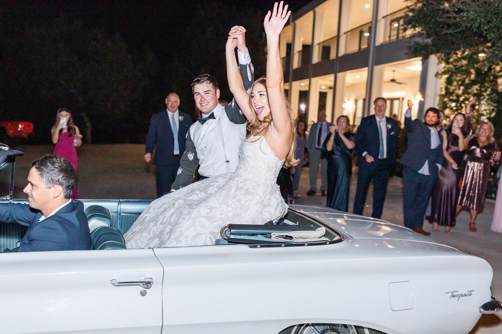 Newlyweds' classic-car exit through a cheering crowd